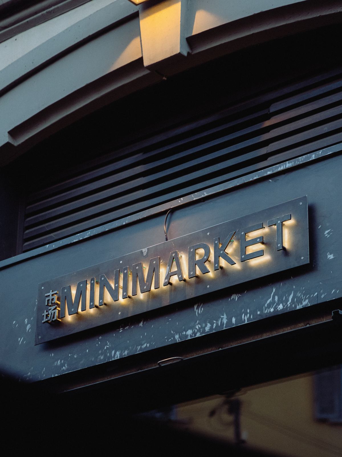 L'insegna in ottone 市场 Minimarket sopra l'ingresso